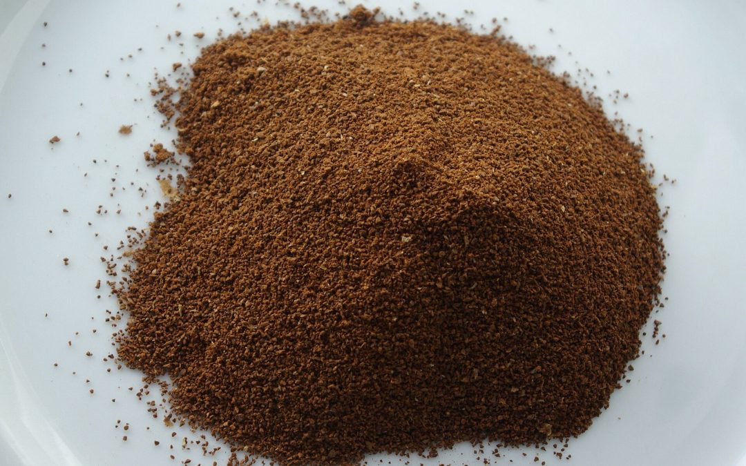 Café tostado y molido sobre un plato blanco